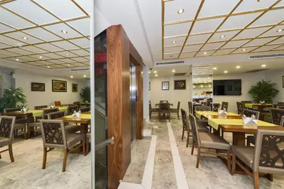 two views of a restaurant with tables and chairs at Darkmen Hotel 2 in Istanbul