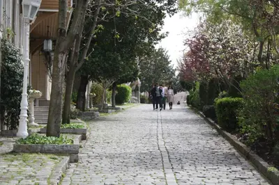 a group of people walking down a cobblestone street at Coskun House in Istanbul