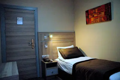 a bedroom with a bed and a door with a night stand at Sinem Hotel & Old City in Istanbul