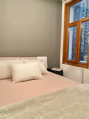 a bedroom with a bed with white pillows and a window at K&Y Apartments in Taksim 2 in Istanbul