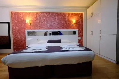 a bedroom with a large bed with a red wall at ottogreensuit in Istanbul