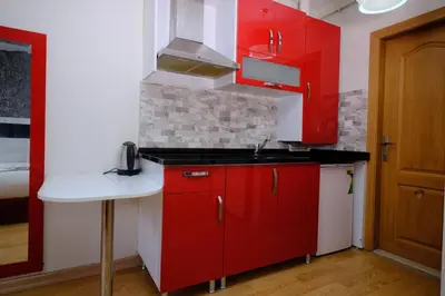 a kitchen with red cabinets and a sink at ottogreensuit in Istanbul