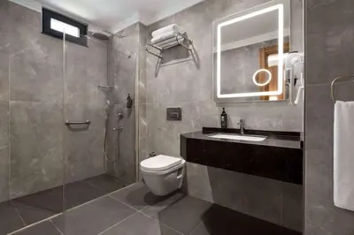 a bathroom with a toilet and a sink and a shower at Ramada Encore by Wyndham Istanbul Sisli in Istanbul
