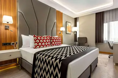 a hotel room with a bed with a black and white blanket at Ramada Encore by Wyndham Istanbul Sisli in Istanbul