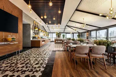a dining room with tables and chairs and windows at Ramada Encore by Wyndham Istanbul Sisli in Istanbul