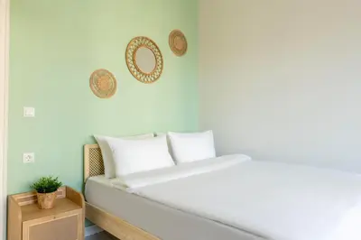 a bed with white pillows and a mirror on the wall at Atlas Han Hotel in Istanbul