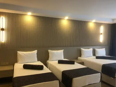 a room with three beds in a room at Grand İska Palace in Istanbul