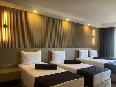a room with three beds in a room at Grand İska Palace in Istanbul