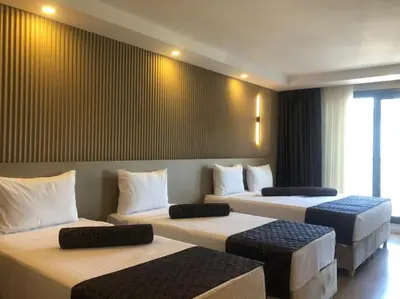 a room with three beds in a room at Grand İska Palace in Istanbul