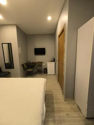 a room with a bed and a table and a television at Ore Pera Suites in Istanbul