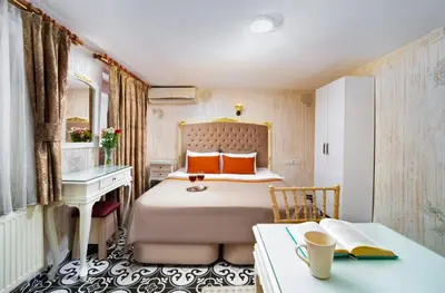 a bedroom with a bed with orange pillows and a desk at Alhambra Apart Hotel in Istanbul