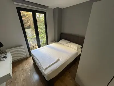 a bed in a room with a large window at Remta Real Estate in Istanbul