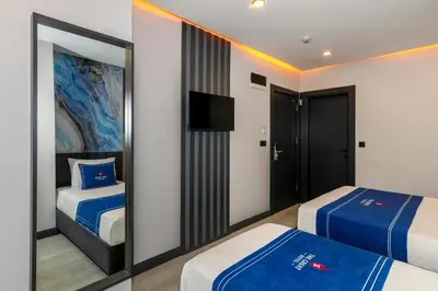 a hotel room with two beds and a mirror at The Great Airport Hotel & Restaurant in Arnavutköy