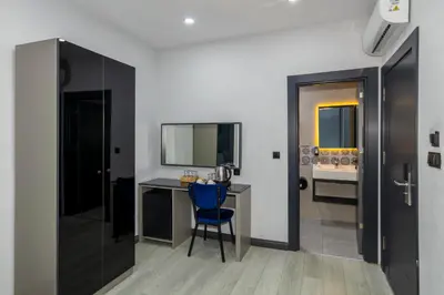 a room with a desk and a blue chair at The Great Airport Hotel & Restaurant in Arnavutköy