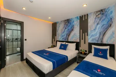 a bedroom with two beds and a painting on the wall at The Great Airport Hotel & Restaurant in Arnavutköy