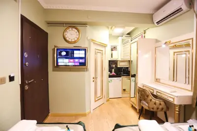 a living room with a clock on the wall and a kitchen at Whıte Moon Hotel Suites in Istanbul