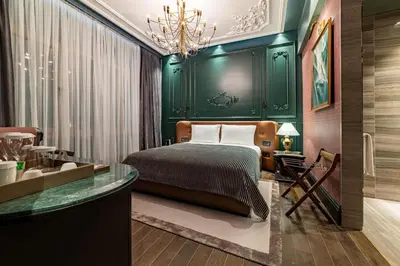 a bedroom with green walls and a bed and a desk at Orient Occident Hotel Istanbul, Autograph Collection in Istanbul