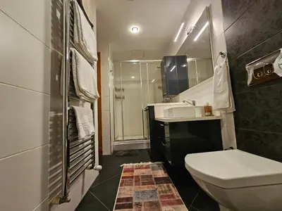 a bathroom with a sink and a toilet and a mirror at TAKSiM PERFECT RESiDENCE, 3 BEDROOMS, 140 M2, POOL GYM SAUNA ACCESS in Istanbul