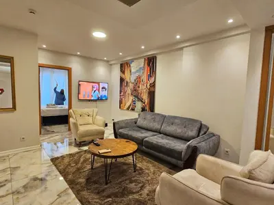 a living room with a couch and a table at PERFECT RESİDENCE TAKSİM, 2 BEDROOM, POOL, Gym, Sauna in Istanbul