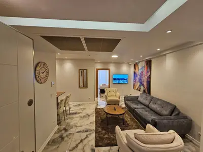 a living room with a couch and a table at PERFECT RESİDENCE TAKSİM, 2 BEDROOM, POOL, Gym, Sauna in Istanbul