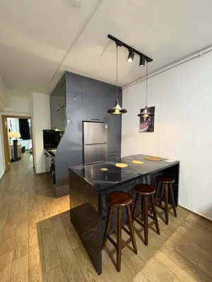 a kitchen with a black island with bar stools at Cosy flat nearTaksim/Nişantaşi in Istanbul