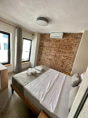 a bedroom with a large bed with a brick wall at Elegance House Hotel in Istanbul
