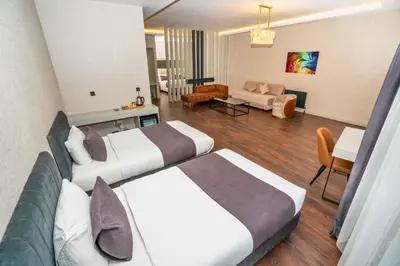 a hotel room with two beds and a living room at 216 Station Suite Gebze in Gebze
