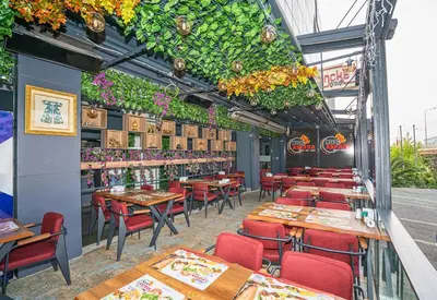 a restaurant with tables and chairs and plants at 216 Station Suite Gebze in Gebze