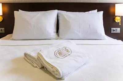 a white towel sitting on a bed with pillows at Mays Royal Hotel in Istanbul