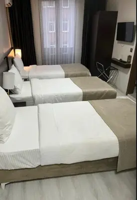a group of three beds in a hotel room at Mays Royal Hotel in Istanbul