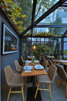 a dining room with tables and chairs and windows at Alilass Hotel in Istanbul