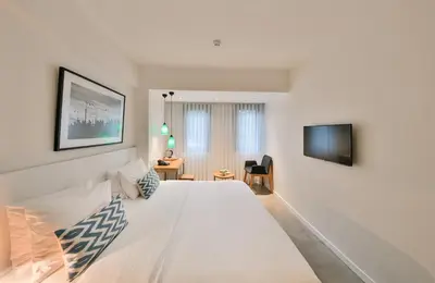 a bedroom with a large white bed and a television at Alilass Hotel in Istanbul