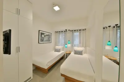 a white room with two beds and a tv at Alilass Hotel in Istanbul