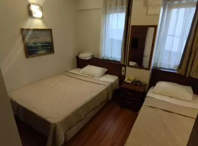 a hotel room with two beds and a mirror at Hotel Nayla in Istanbul