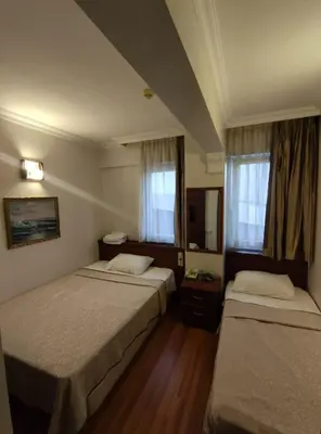 a hotel room with two beds and two windows at Hotel Nayla in Istanbul