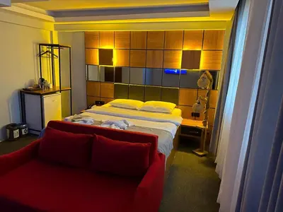 a bedroom with a bed and a red couch at Kadıköy Linda Hotel in Istanbul