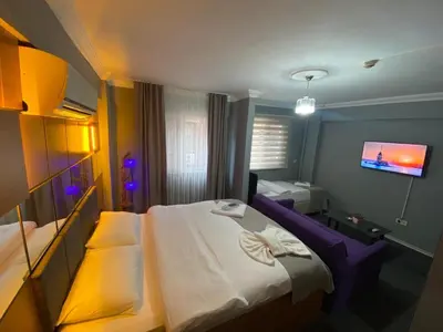 a hotel room with a bed and a flat screen tv at Kadıköy Linda Hotel in Istanbul