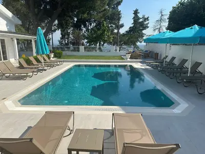 a large swimming pool with chairs and umbrellas at Villa No 44 in Darıca