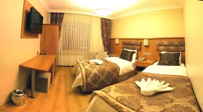 a hotel room with two beds and a television at Besiktas Otel in Istanbul