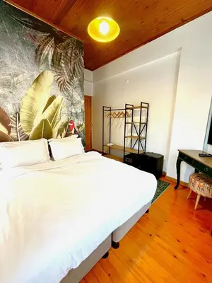 a bedroom with a large white bed with a painting on the wall at Dimora Hotel Kadıköy in Istanbul