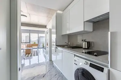 a kitchen with white cabinets and a dishwasher at Scenic Bright Studio w Parking, PoolViews! #302 in Istanbul