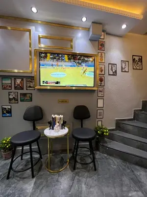 a bar with two stools and a tv on the wall at TAKSİM LARİSSA RESİDENCE in Istanbul