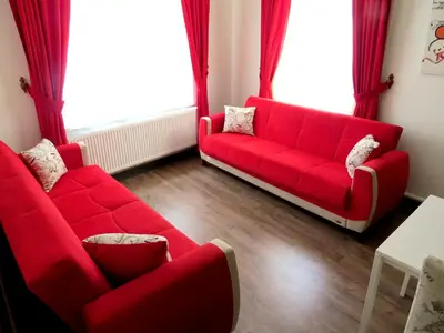 a red couch in a living room with red curtains at Istanberry - Berry Life Apartments in Istanbul