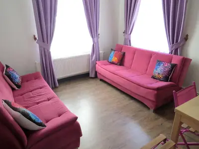 a living room with a pink couch and windows at Istanberry - Berry Life Apartments in Istanbul