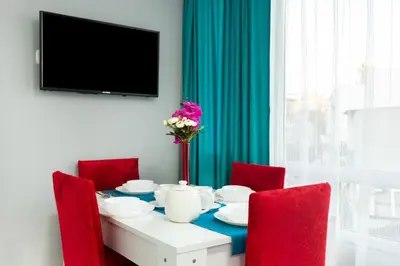 a dining room table with red chairs and a tv at Istanbul House in Istanbul