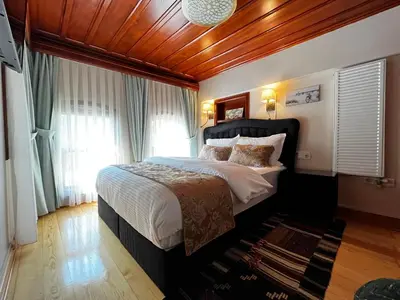 a bedroom with a large bed with a wooden ceiling at Lily Mansion in Istanbul