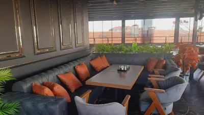 a restaurant with a table and chairs and a bench at Grand royal hotel in Gümüşyaka