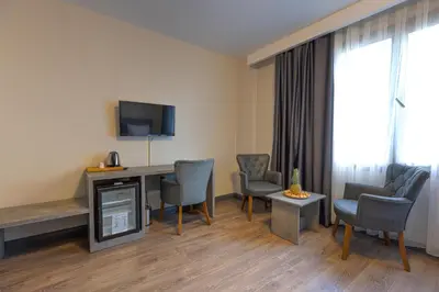a hotel room with a desk and chairs and a television at Grand royal hotel in Gümüşyaka