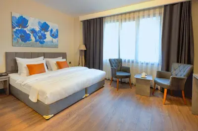 a hotel room with a bed and two chairs at Grand royal hotel in Gümüşyaka