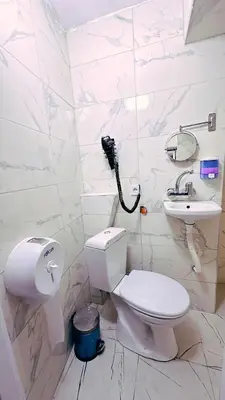 a white bathroom with a toilet and a sink at Taksim Centre Hotel in Istanbul